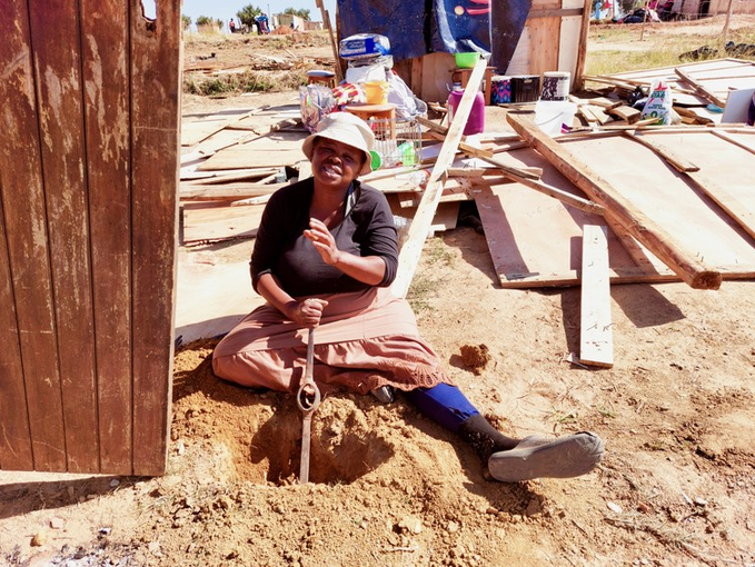 woman-sitting-outside-shack-others-demolished-in-the-country